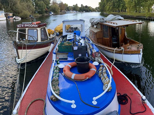 Tug towing two other boats on the river